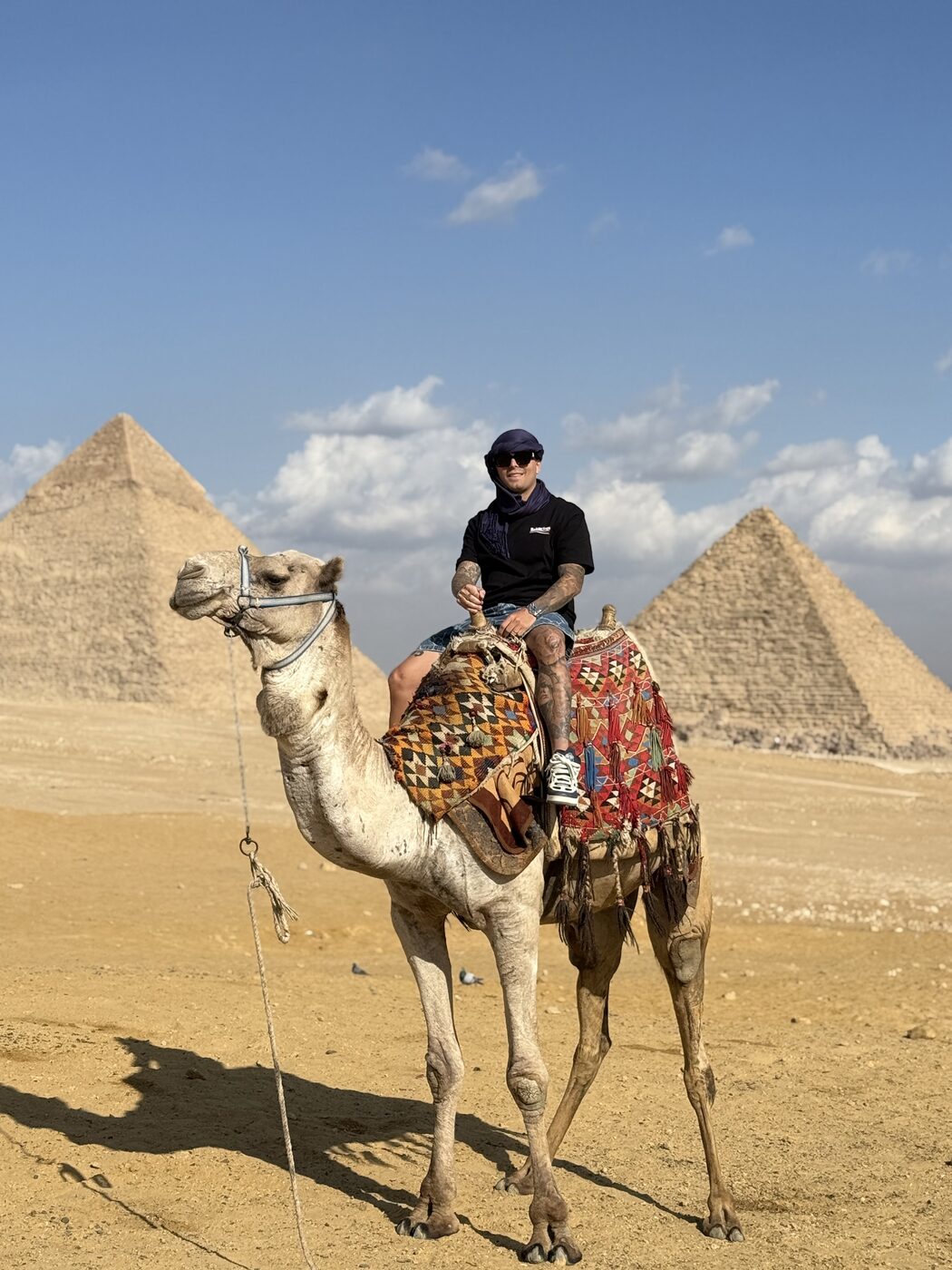 Agustin LV en camello frente a las pirámides de Egipto